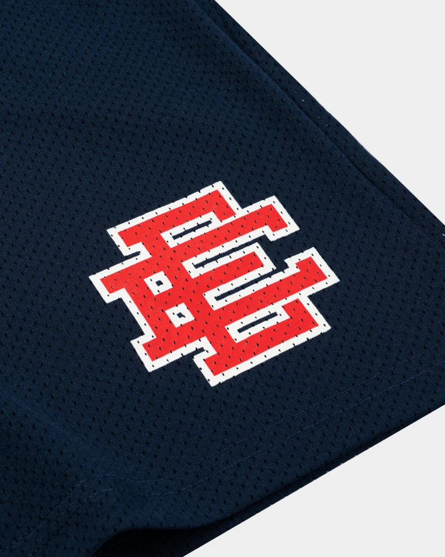 Close-up of Eric Emanuel navy shorts showing red and white embroidered logo on mesh fabric