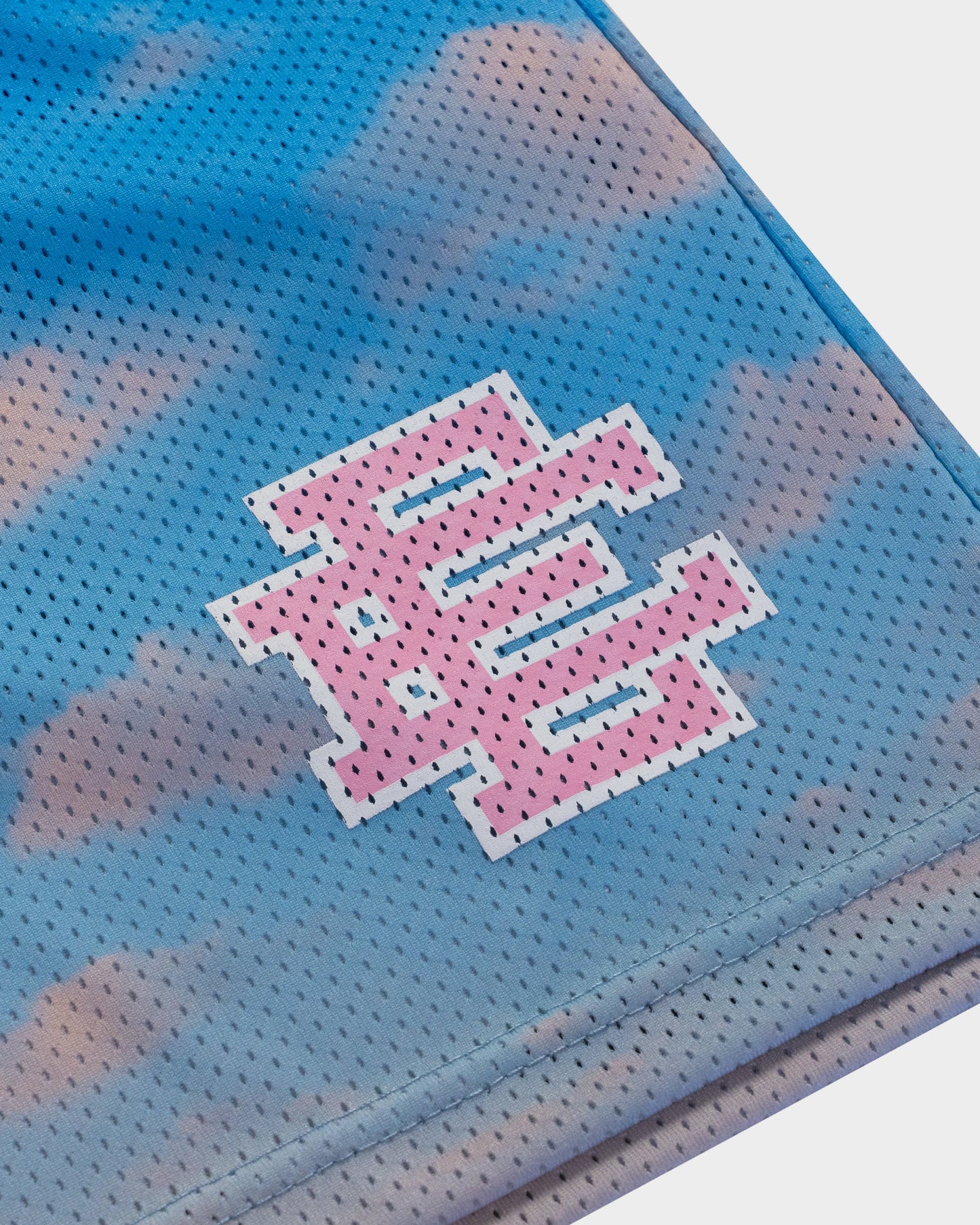 Close-up of blue and pink mens designer athletic shorts with perforated fabric and logo detail