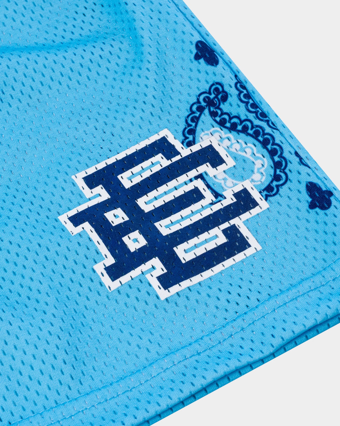 Close-up of blue designer athletic shorts for summer with printed navy logo and paisley pattern