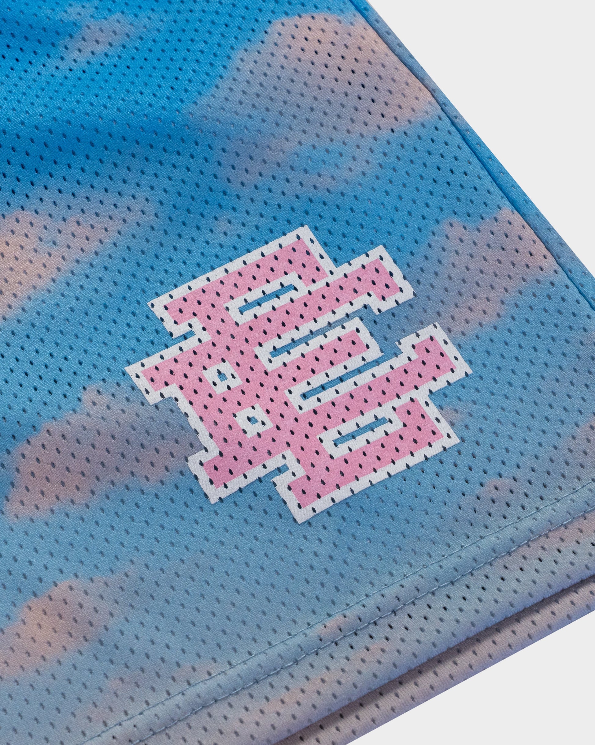 Close-up of blue and pink mens designer athletic shorts with perforated fabric and logo detail