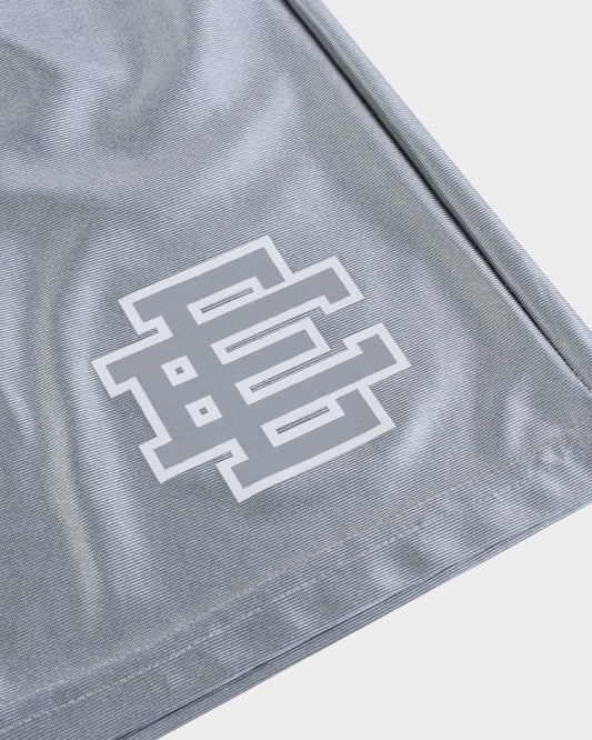 Close-up of gray premium baggy athletic shorts fabric with white geometric logo print